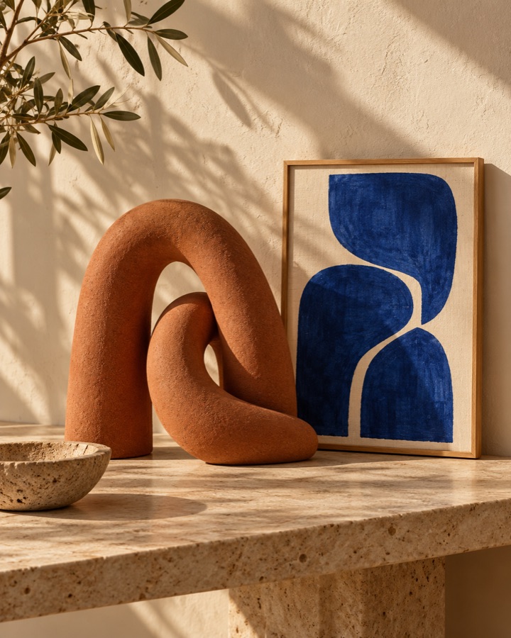 A terracotta sculpture beside a blue abstract artwork